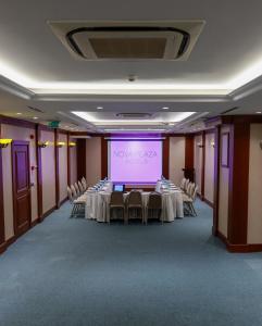 une salle avec des tables, des chaises et un écran de projection dans l'établissement Nova Plaza Park Hotel, à Istanbul