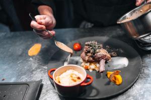 a person eating a plate of food on a table at Le Coucou Hotel Restaurant & Lounge-Bar in Montreux