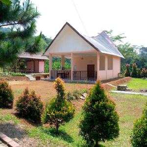 uma pequena casa com duas árvores de Natal no quintal em Duren medan Twbm Rumpin em Sawah