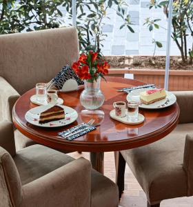 una mesa de madera con tarta y tazas de café. en Nova Plaza Park Hotel, en Estambul