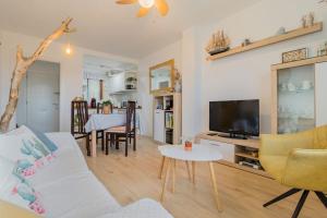 Apartamento mogro playa في موغرو: غرفة معيشة مع أريكة وتلفزيون وطاولة