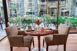 une table avec deux chaises et une table avec des fleurs. dans l'établissement Nova Plaza Park Hotel, à Istanbul
