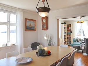 uma sala de estar com uma mesa de jantar com cadeiras em Holiday home LYNGØR 