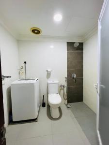 a white bathroom with a toilet and a shower at The Hill Regency in Bentong