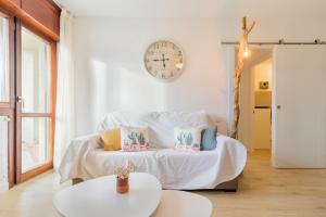 Habitación con cama con reloj en la pared en Apartamento mogro playa, en Mogro
