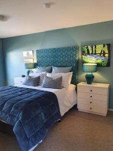 a bedroom with a large bed with a blue wall at The Tin Hut in Blenheim