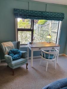 a desk and chair in a room with a window at The Tin Hut in Blenheim
