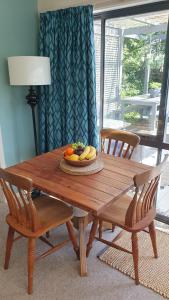 a wooden table with a plate of fruit on it at The Tin Hut in Blenheim
