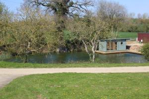 a small house in the middle of a river at The Woodpecker shepherd hut in Elmswell