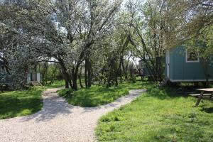 a campsite with a bench and a picnic table and trees at The Woodpecker shepherd hut in Elmswell