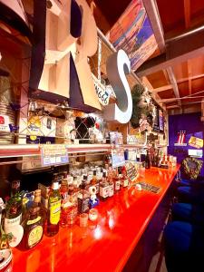 - un bar avec un comptoir rouge et des bouteilles d'alcool dans l'établissement RSDvillage, à Miura