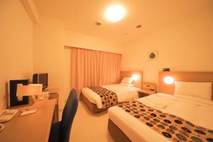 Habitación de hotel con 2 camas y escritorio en Smile Hotel Okinawa Naha (Tomari Port), en Naha
