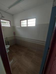 ケパラ・バタスにあるMuslim Nur Homestayの空のバスルーム(トイレ付)、窓2つが備わります。