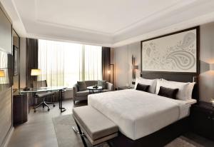 a hotel room with a large bed and a desk at JW Marriott Hotel Kolkata in Kolkata