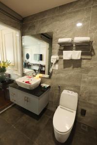 ein Badezimmer mit einem weißen WC und einem Waschbecken in der Unterkunft Royal Văn Phú Hotel in Hanoi