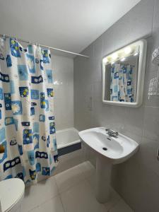 a bathroom with a sink and a shower curtain at Alpen1 Europeñiscola in Peñíscola