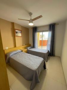 1 dormitorio con 2 camas y ventana en Alpen1 Europeñiscola, en Peñíscola