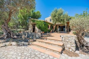 een stenen huis met bomen en een pad bij Noguera -Pollensa in Pollença