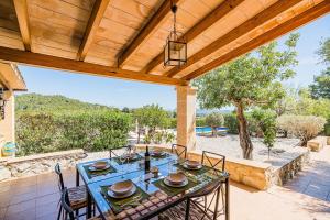 a patio with a table and chairs and a wooden ceiling at Noguera -Pollensa in Pollença