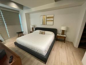 1 dormitorio con 1 cama, 2 mesas y una ventana en Apartamento en Lobby33, en Guadalajara