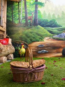 a painting of a forest with a bird standing in a basket at URBAN PIC NIC in Piazza Brembana