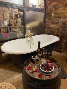 a bath tub with a table with glasses of wine at Al Silter in Capriate San Gervasio