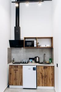 a kitchen with wooden cabinets and a white refrigerator at RESA apart - нові smart-квартири біля річки in Uzhhorod