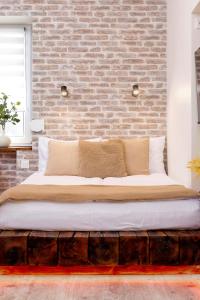 クラクフにあるWOW Apartment by Cozyplaceのレンガの壁の客室で、大型ベッド1台を利用できます。