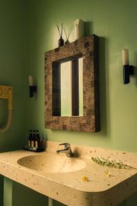 lavabo en el baño con espejo en una pared verde en Ecosfera Hotel, Yoga & Spa, en Canggu