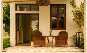 a patio with chairs and a table in front of a house at Ecosfera Hotel & Spa in Canggu