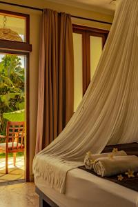 a bedroom with a bed with a mosquito net at Ecosfera Hotel, Yoga & Spa in Canggu