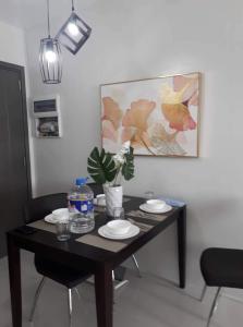 a dining room table with plates and a plant on it at Camella Manor Majorca 7A in Bacolod
