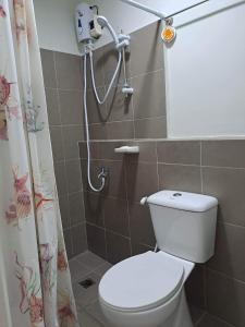 a bathroom with a toilet and a shower at Camella Manor Majorca 7A in Bacolod
