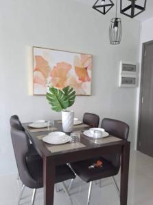 une table à manger avec des chaises et une plante en pot dans l'établissement Camella Manor Majorca 7A, à Bacolod