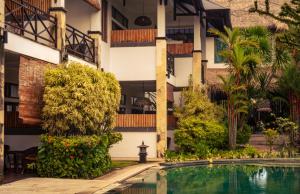 a hotel with a swimming pool in front of a building at Ecosfera Hotel & Spa in Canggu