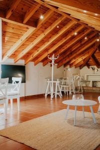 トレ・デル・マールにあるMares - Aticの木製の天井、白い椅子とテーブルが備わる客室です。