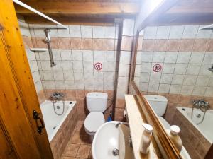 a bathroom with two toilets and a sink and a tub at Poseidon's Pool Paradise in Skarinou