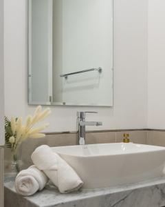 a bathroom with a sink and a mirror and towels at Cozy and Spacious l Big Terrace in Dubai