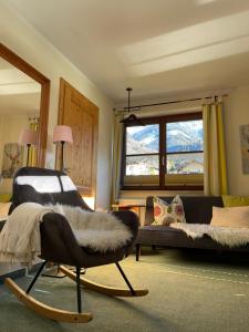 ein Wohnzimmer mit einem Sofa und einem Stuhl in der Unterkunft Landhaus Rieser in Bad Hofgastein