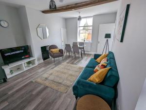uma sala de estar com um sofá azul e uma televisão em 31 High Street - Modern & Stylish 2-bed Apartment - inc parking em Husbands Bosworth