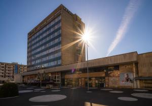 wysoki budynek ze świecącym słońcem w obiekcie Hotel Vsacan w mieście Vsetín