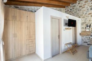 a room with a door and a wall with a tv at Piedra Residence in Pigi