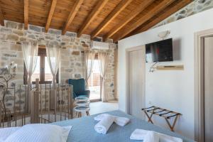 a bedroom with a bed and a tv on the wall at Piedra Residence in Pigi