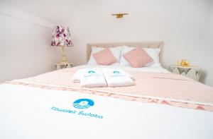 ein Bett mit rosa und weißen Kissen darauf in der Unterkunft KAWAŁEK ŚWIATA in Darłowo