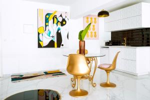een keuken met gouden stoelen en een tafel bij New Leventis Luxury Κing Suite 41-Central Location in Ayia Napa