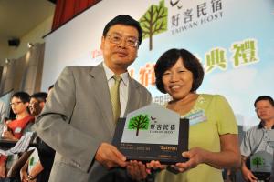 a man and a woman holding up a plaque at Yunju House in Jiaoxi