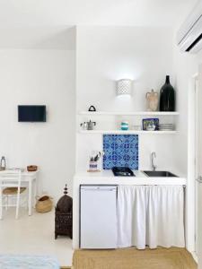 a white kitchen with a sink and a table at Agata B&B in Lipari