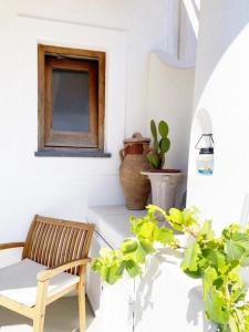a room with a chair and a table with a plant at Agata B&B in Lipari