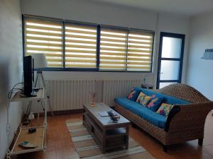 ein Wohnzimmer mit einer blauen Couch und einem Couchtisch in der Unterkunft Gite la Nouette in La Tremblade