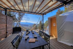 a table and chairs on a deck with a view at Retreat Camp Mahoroba in Fujikawaguchiko